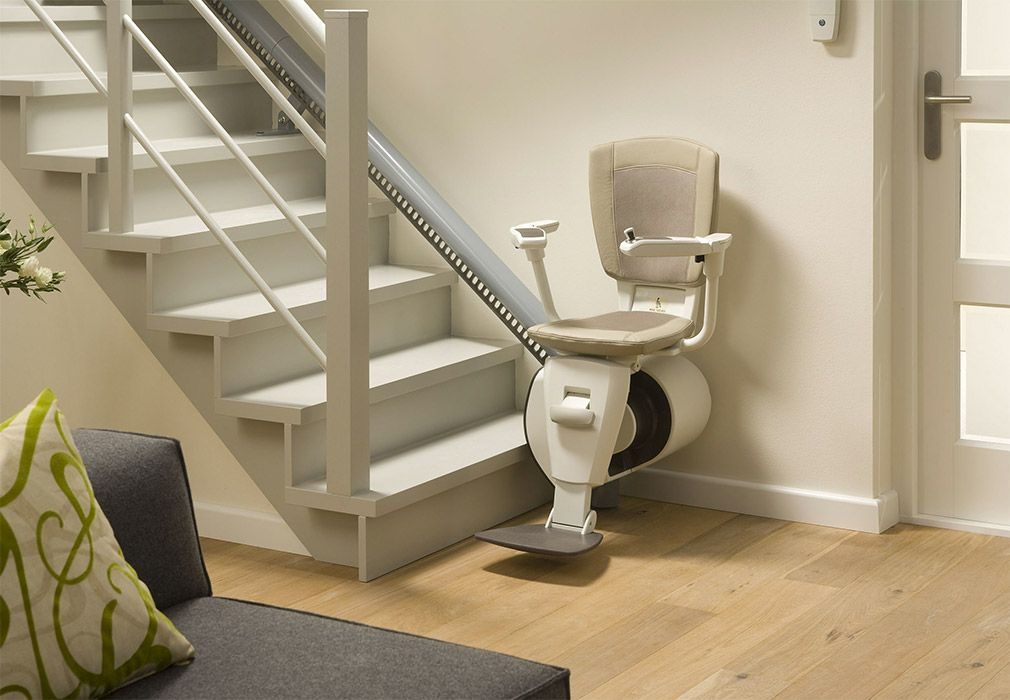 Curved Stairlifts for Safe Home Access: Curved stairlift with a beige seat parked beside a white open staircase in a modern home
