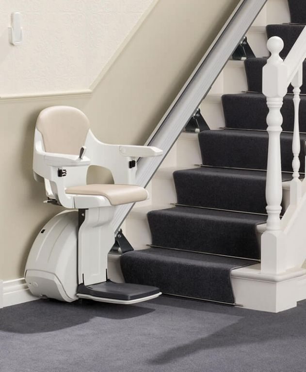 Stairlifts for Enhanced Mobility Solutions: White straight stairlift with a cream seat at the bottom of a carpeted staircase